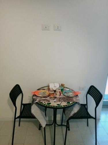 a table with chairs and a table with food on it at La casa sul tetto, Room's & Glamping in Recanati