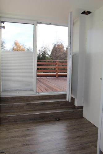 an empty room with a door open to a deck at Pension Brunnenhof in Roetgen