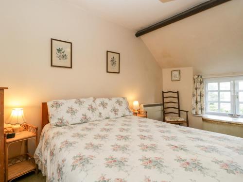 Un dormitorio con una cama grande y una ventana en Yeoman Cottage, en Crewkerne