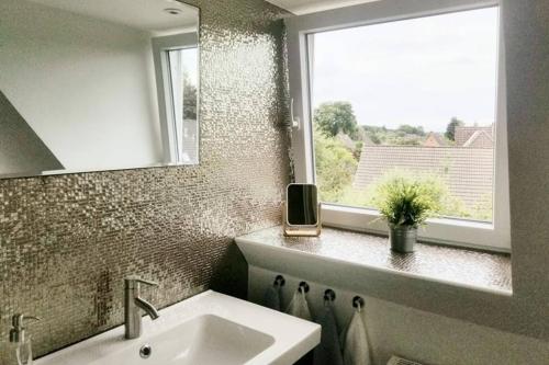 baño con lavabo y ventana en Villa Pries, en Kiel