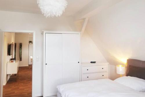 a bedroom with a white bed and a chandelier at Villa Pries in Kiel