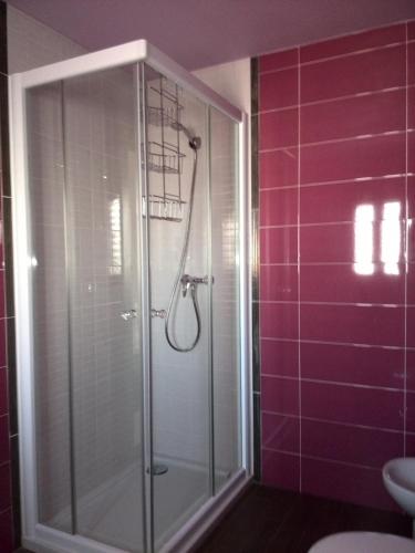 a glass shower in a bathroom with purple tiles at Can Mossènyer in San Antonio