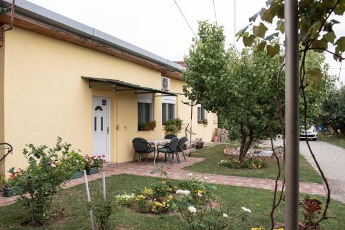 a house with a table and chairs in the yard at Apartman Peric in Đakovo