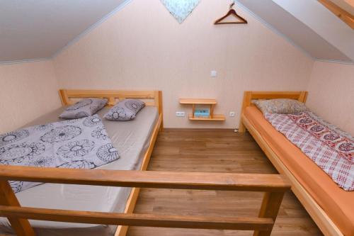 two bunk beds in a room with wooden floors at Vasarnamis Zarasuose in Zarasai
