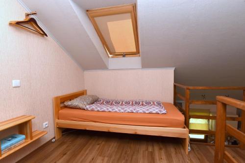 a bedroom with a bed with a mirror on the wall at Vasarnamis Zarasuose in Zarasai