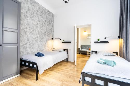 sypialnia z 2 łóżkami i kanapą w obiekcie Pod arkadami w Warszawie