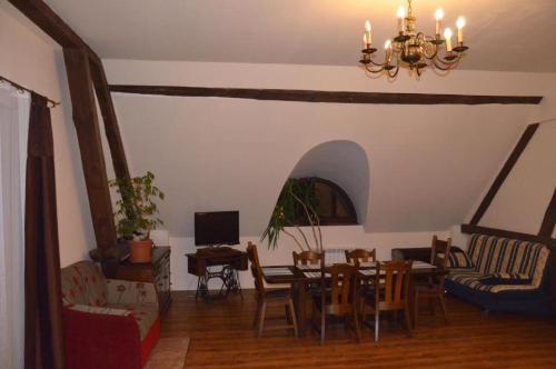 uma sala de estar com uma mesa e cadeiras e um lustre em SPICHLERZ em Rachanie