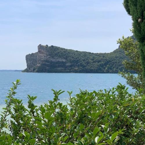 a large body of water with a mountain in the background at Resort Borgo del Torchio in Manerba del Garda