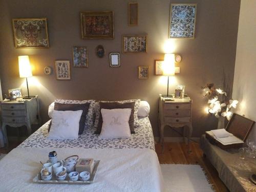 バイヨンヌにあるラ シャンブル ドット ドゥマーノ サントルヴィル デ バイヨンヌのベッドルーム1室(白いベッド1台、テーブル2台、ランプ2つ付)