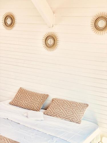 - un lit avec deux oreillers et deux miroirs sur le mur dans l'établissement Appartement à 150 m de la mer, à La Seyne-sur-Mer