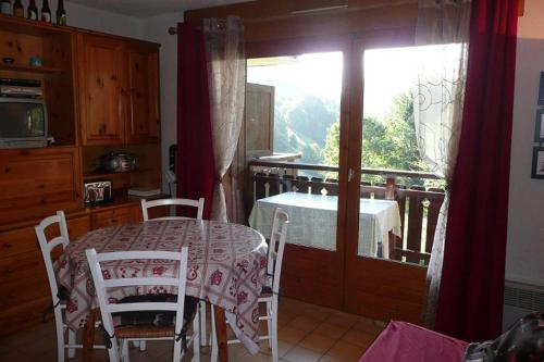 una cucina con tavolo, sedie e finestra di Les Chalets du Pounant - Alpes du Léman a Bellevaux