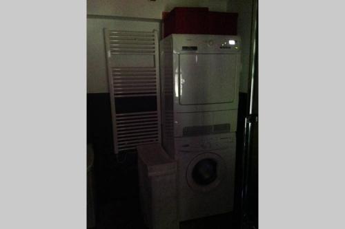 a kitchen with a washing machine and a microwave at Chalet “In dai Guriuz” in Ravinis
