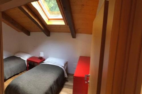 two beds in a small room with a window at Chalet “In dai Guriuz” in Ravinis