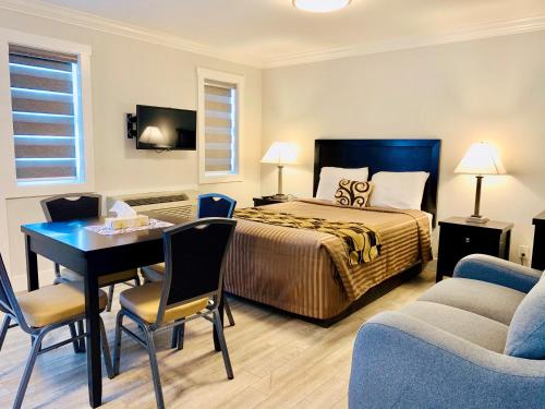 um quarto de hotel com uma cama, uma mesa e cadeiras em Traveler's Motel Penticton em Penticton