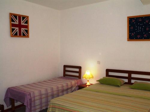two beds in a room with a flag on the wall at Edificio Magico in Tarrafal