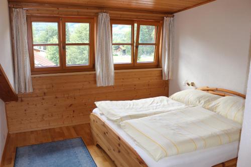 een slaapkamer met een bed in een kamer met ramen bij Ferienwohnung Johanna in Bad Goisern
