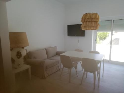a living room with a couch and a table and chairs at Casa do Jardim in Beja