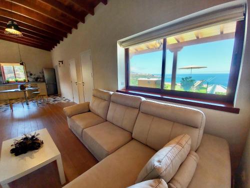 a living room with a couch and a large window at Papaya Paradise in La Orotava