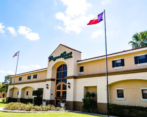 a building with a flag in front of it at Vineyard Court Designer Suites Hotel in College Station
