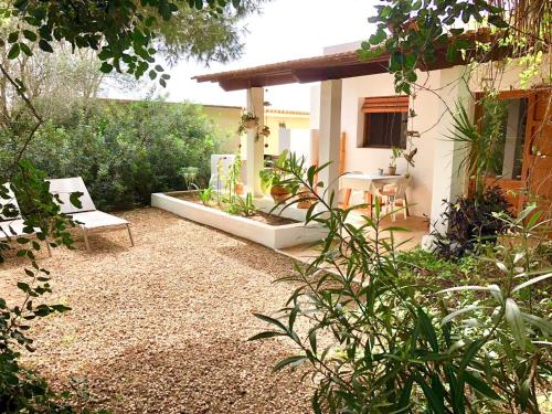 a garden with a bench and a table and chairs at Can Xicu Castello in San Ferrán de ses Roques