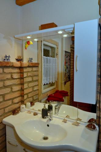 a bathroom with a sink and a large mirror at Adél Apartman in Kaposvár