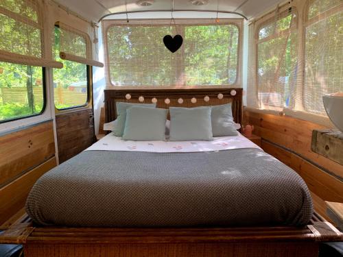 Una cama o camas en una habitación de Magic Roof Top Bus with big bath in the tree forest!