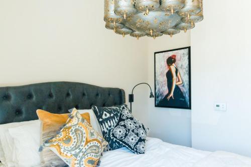 a bedroom with a bed with pillows and a chandelier at The Bishop Arts Hotel by Qresorts in Dallas