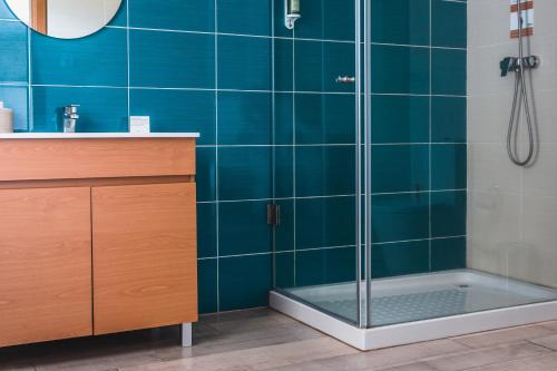 a bathroom with a shower with blue tiles at Quinta Ponte da Capinha in Capinha