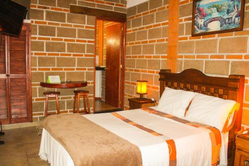 um quarto com uma cama e uma parede de tijolos em Hospedaje Piedra de Sol em Tepoztlán