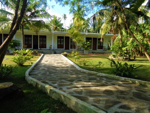 a house with a walkway in front of a yard at New Holiday Reach in Unawatuna