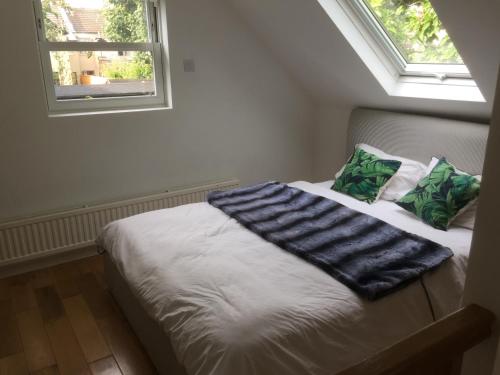 a bed in a room with a window at The Coach House in Bickley