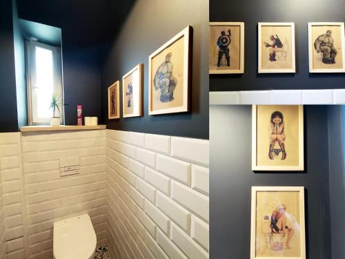 een badkamer met foto's aan de muur en een toilet bij Och!hostel in Gdynia