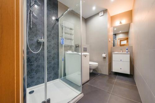 a bathroom with a glass shower and a toilet at Apartament4siostry65 in Ustronie Morskie