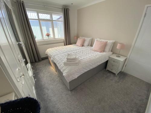 a bedroom with a bed with pink pillows and a window at COLERIDGE LODGE in Thornton