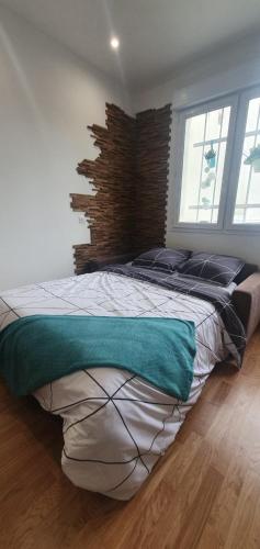 a bedroom with a large bed with a brick wall at Le Paon chaleureux et calme entre Paris et Disneyland in Ozoir-la-Ferrière