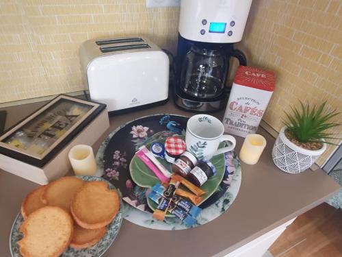 een tafel met een bord eten en een kopje koffie bij Le Paon chaleureux et calme entre Paris et Disneyland in Ozoir-la-Ferrière