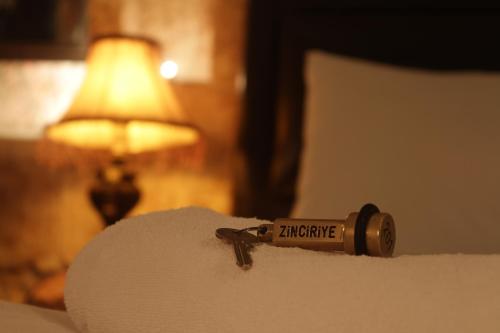 a bottle of ammunition sitting on top of a bed at Zinciriye Hotel in Mardin
