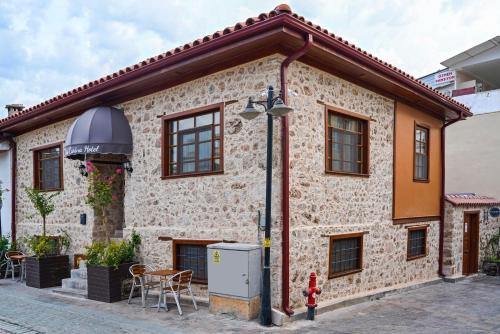 a brick house with windows and a fire hydrant at La Casa Carina Butik Otel in Antalya