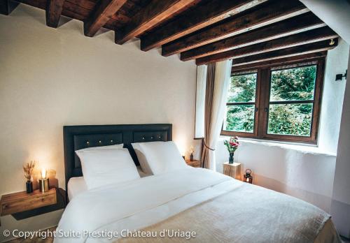 - une chambre avec un lit doté de draps blancs et une fenêtre dans l'établissement Suite Prestige Château Uriage - Escapade romantique, à Saint-Martin-dʼUriage