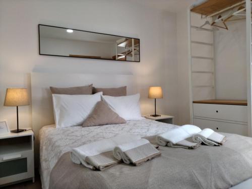 a bedroom with a bed with towels and a mirror at Casa da Ponte in Mirandela
