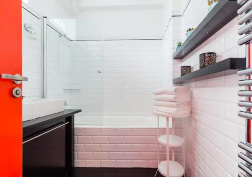 La salle de bains est pourvue d'un lavabo et d'une douche avec du carrelage rose. dans l'établissement Atelier d Artiste Le Marais Paris - exceptionnel !, à Paris