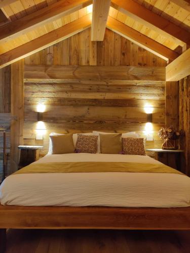 Cama en habitación con paredes de madera en Au Fond du Bourg VDA Jovencan 0001 - 0002, en Aosta