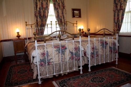 a bedroom with a canopy bed with flowers on it at The Royal Hotel Pilgrims Rest in Pilgrim's Rest