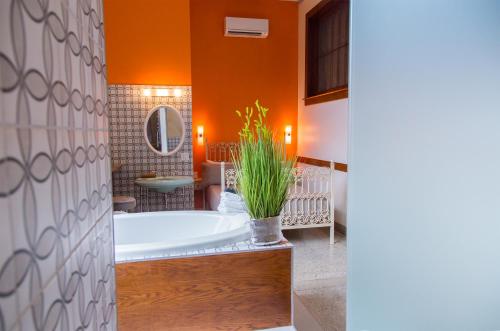 an orange bathroom with a tub and a potted plant at School 31 Lofts in Rochester