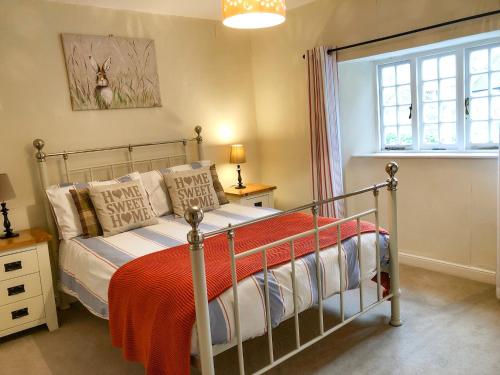 a bedroom with a metal bed with a red blanket at Little Dragons in Dunster