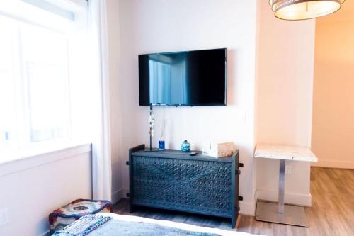 a living room with a tv on a wall at The Bishop Arts Hotel by Qresorts in Dallas