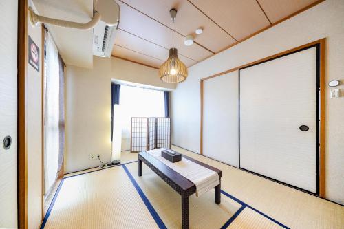 una habitación con un banco frente a una puerta en Du Etowaaru, en Nagoya