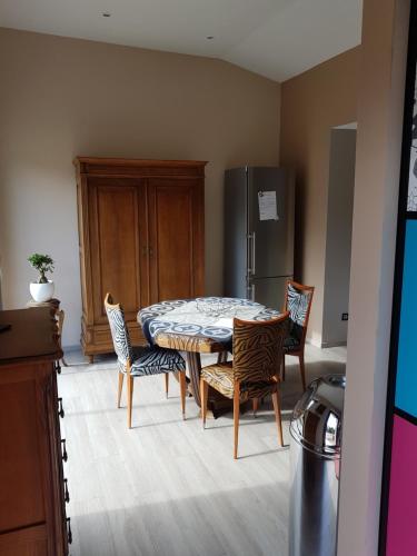 a kitchen with a table and chairs and a refrigerator at LA MAISON DE LOUISE in Pierre-Percée