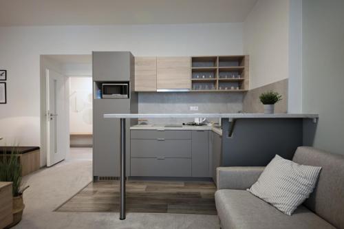 a kitchen with a counter and a couch in a room at HONEST Smichov in Prague
