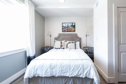 a bedroom with a bed with white bedding and pillows at The Bishop Arts Hotel by Qresorts in Dallas